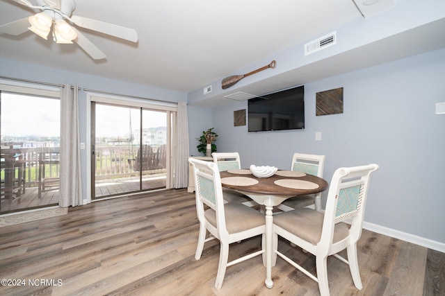 dining space with baseboards, visible vents, ceiling fan, and wood finished floors