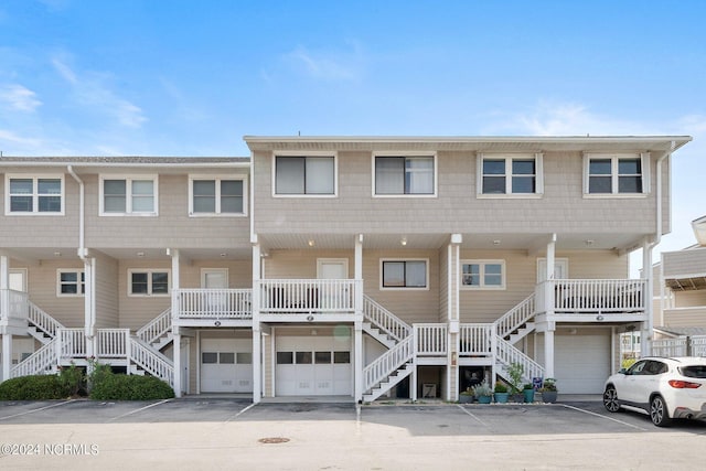 view of property featuring a garage, stairway, and a porch