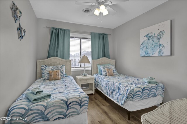 bedroom with visible vents, ceiling fan, and wood finished floors