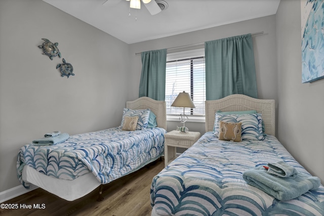 bedroom featuring ceiling fan, baseboards, and wood finished floors