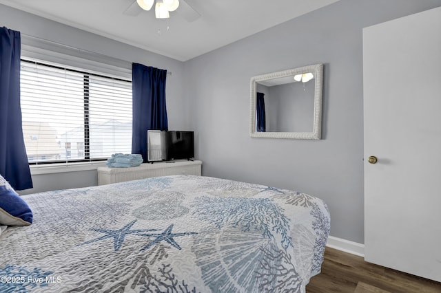 bedroom with ceiling fan, wood finished floors, and baseboards