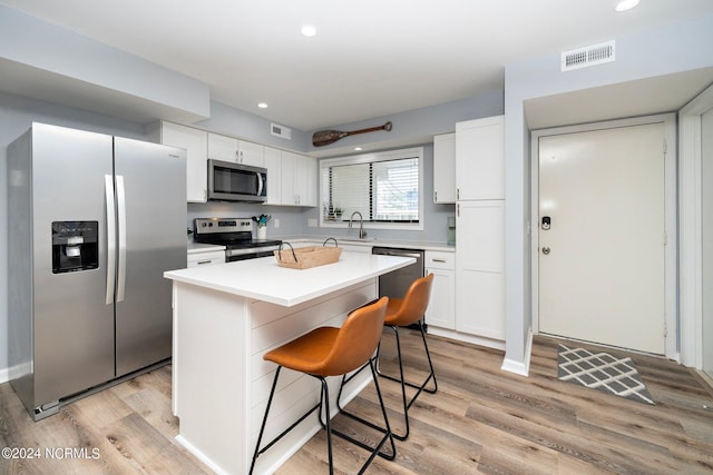 kitchen with light wood-style floors, white cabinetry, visible vents, and stainless steel appliances