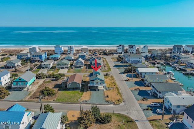 bird's eye view featuring a view of the beach, a water view, and a residential view