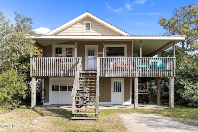 view of front of property with covered porch, dirt driveway, stairway, and metal roof