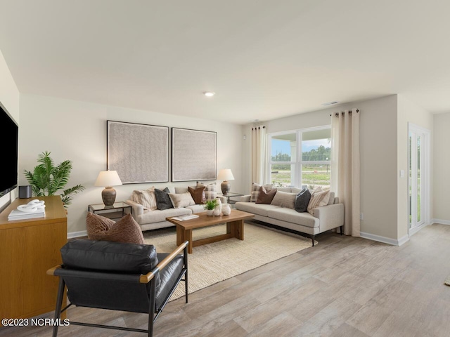 living area featuring light wood-type flooring and baseboards