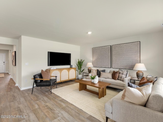 living area featuring recessed lighting, baseboards, and light wood finished floors