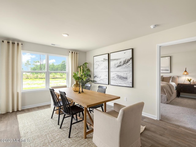 dining area with wood finished floors, visible vents, and baseboards