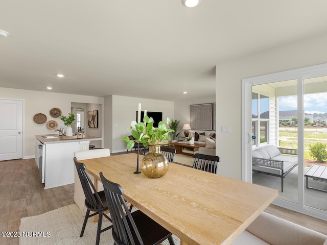 dining area featuring light wood finished floors, baseboards, and recessed lighting