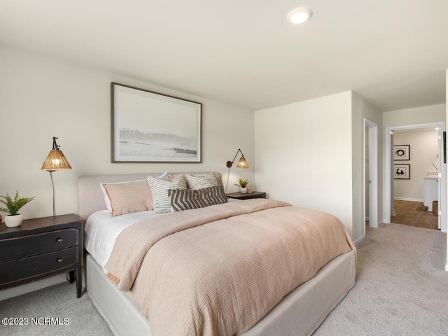 bedroom featuring light colored carpet and baseboards