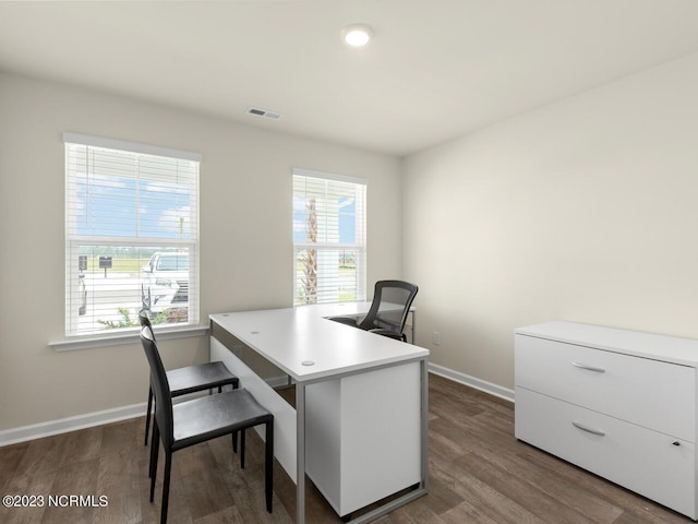 home office featuring dark wood-style floors, a wealth of natural light, visible vents, and baseboards