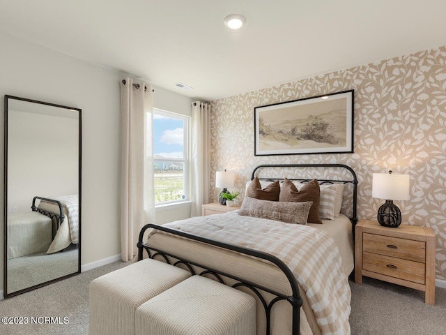 carpeted bedroom with visible vents, baseboards, and wallpapered walls