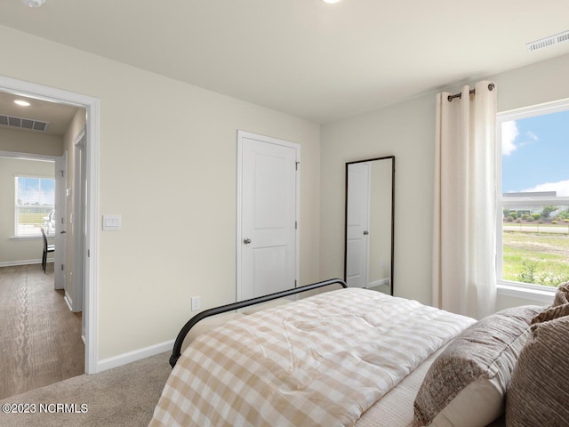 bedroom featuring multiple windows, visible vents, and baseboards