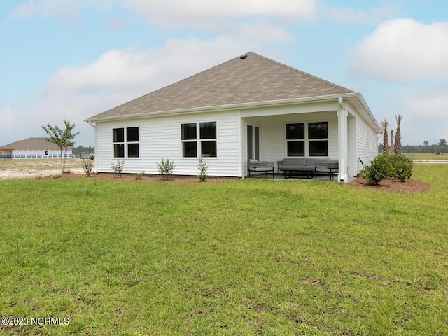 back of house featuring a yard and a shingled roof