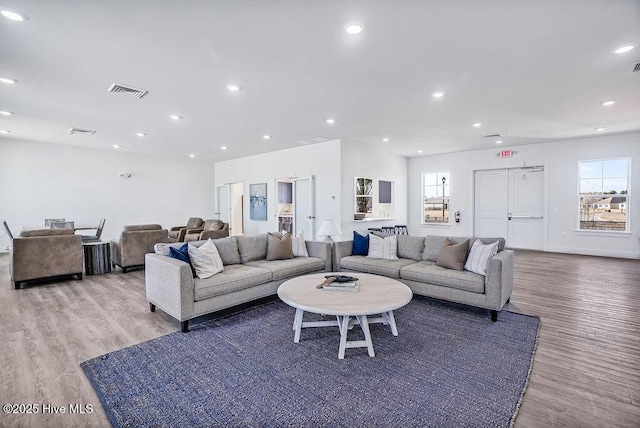 living area featuring light wood-type flooring, visible vents, and recessed lighting