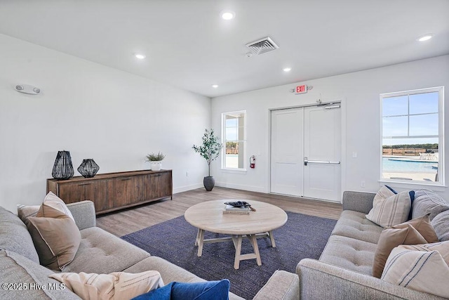 living area featuring light wood-type flooring, baseboards, visible vents, and recessed lighting