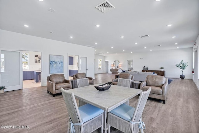 dining space with light wood finished floors, visible vents, and recessed lighting