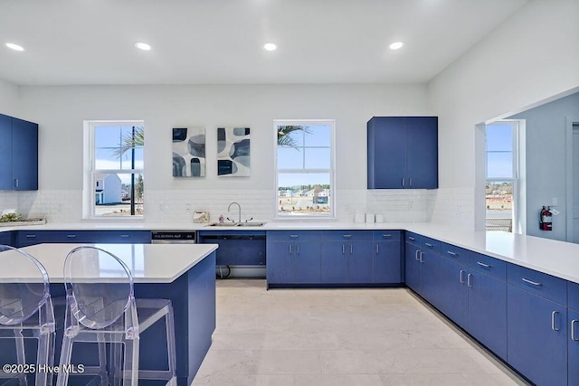 kitchen with blue cabinets, light countertops, and a sink