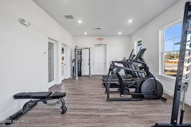 exercise room featuring baseboards, visible vents, wood finished floors, and recessed lighting