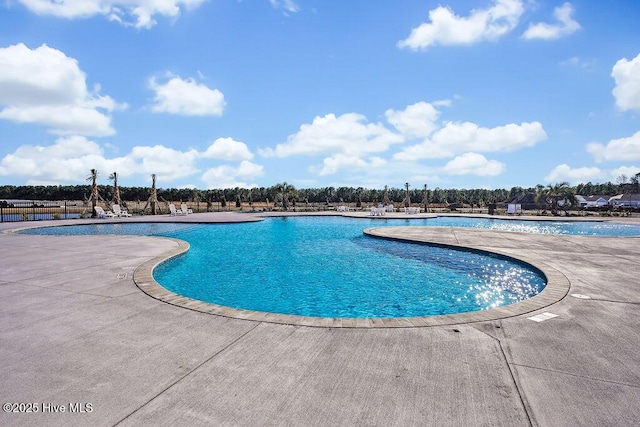 community pool with fence and a patio