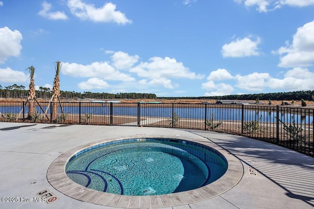 view of swimming pool with a water view and a hot tub