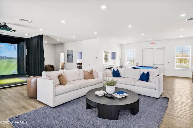 living room featuring light wood-type flooring, visible vents, and recessed lighting