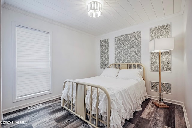 bedroom featuring baseboards, ornamental molding, and dark wood-type flooring