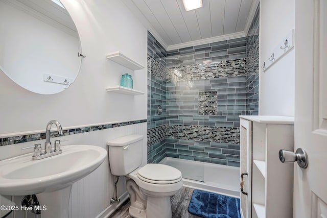 bathroom featuring toilet, wood finished floors, a sink, ornamental molding, and a stall shower