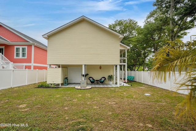 rear view of house with a patio area, a fenced backyard, and a yard