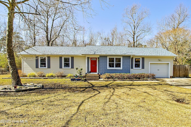 ranch-style home with a shingled roof, a front lawn, fence, concrete driveway, and a garage