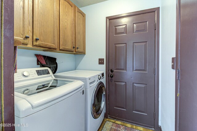 washroom featuring cabinet space and washing machine and clothes dryer