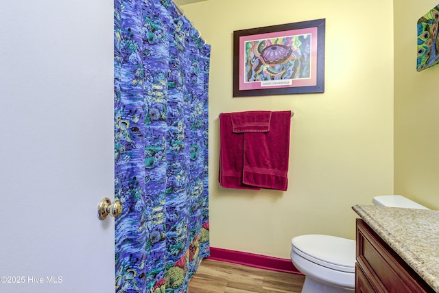 full bath featuring curtained shower, toilet, wood finished floors, and vanity