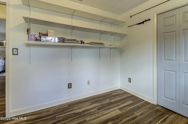 unfurnished room featuring baseboards, a textured ceiling, and dark wood-style floors