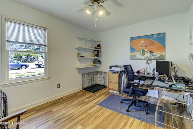 office space with a ceiling fan, wood finished floors, baseboards, and a textured ceiling