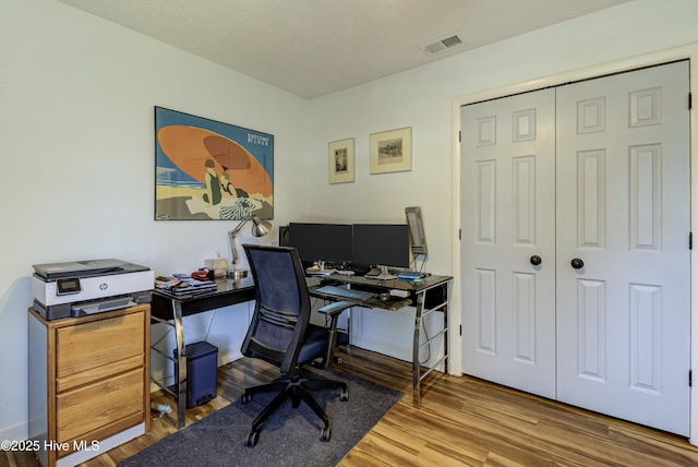 office space with visible vents and wood finished floors