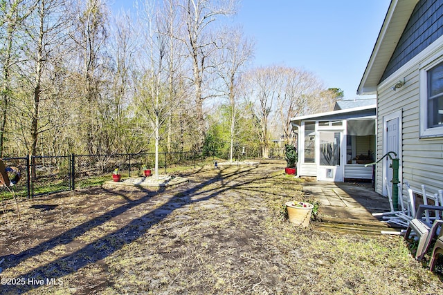 view of yard with a patio, fence, and a sunroom