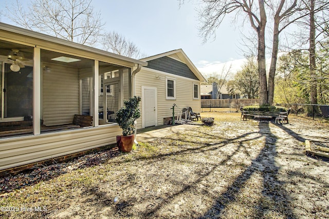 view of side of home featuring a patio area, fence private yard, and a sunroom