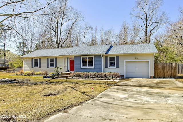 ranch-style home featuring concrete driveway, roof with shingles, a garage, and fence