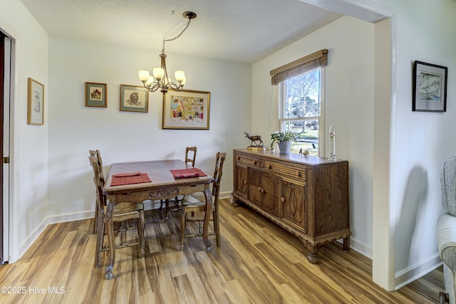 dining area featuring light wood-type flooring and baseboards