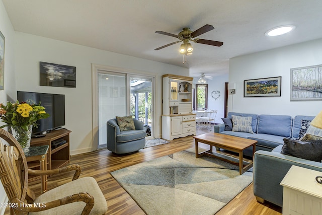 living area featuring light wood-style floors and a ceiling fan