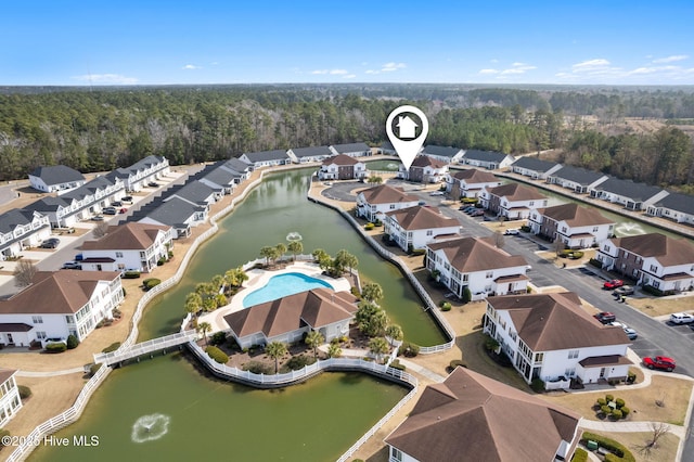 drone / aerial view with a water view, a residential view, and a view of trees