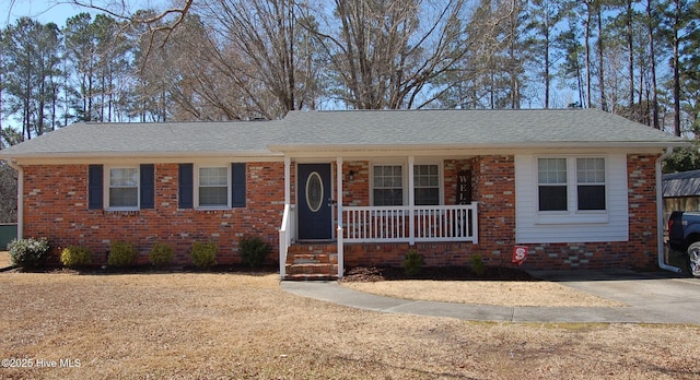 single story home with a porch, brick siding, and a shingled roof