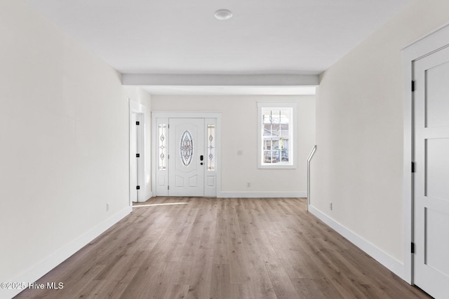 foyer entrance with light wood-style floors and baseboards