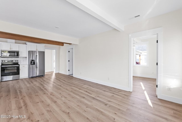 unfurnished living room featuring light wood-style floors, baseboards, visible vents, and beamed ceiling