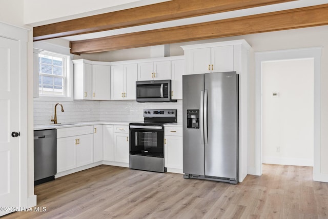 kitchen featuring decorative backsplash, appliances with stainless steel finishes, a sink, light countertops, and beam ceiling
