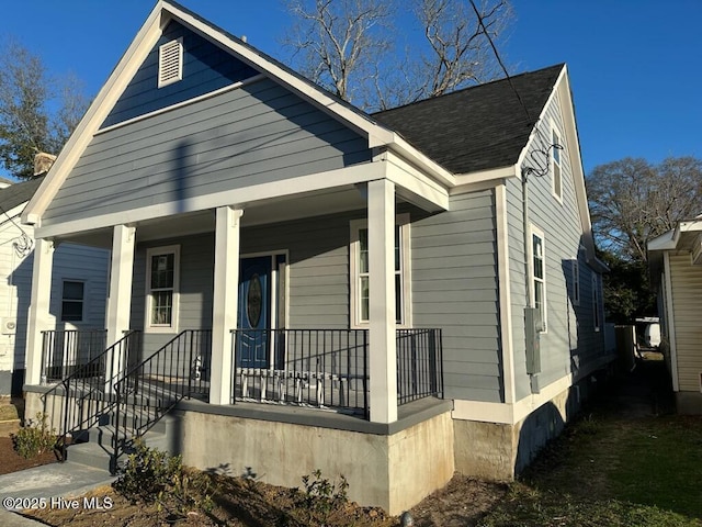 view of front of property featuring covered porch and roof with shingles