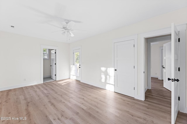 spare room featuring ceiling fan, light wood-type flooring, visible vents, and baseboards