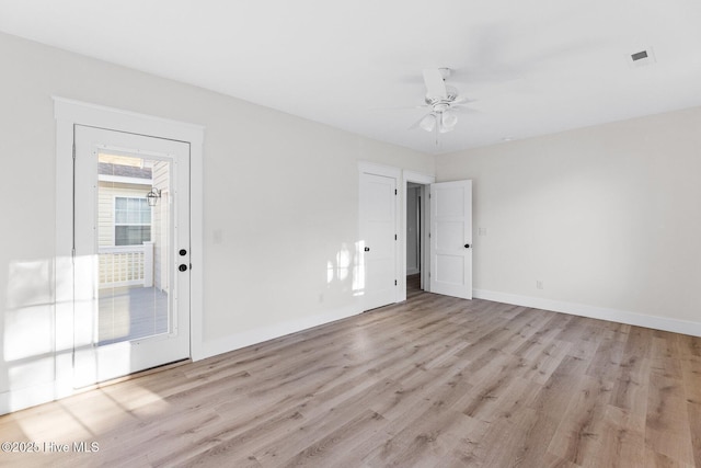 empty room featuring light wood finished floors, baseboards, visible vents, and ceiling fan