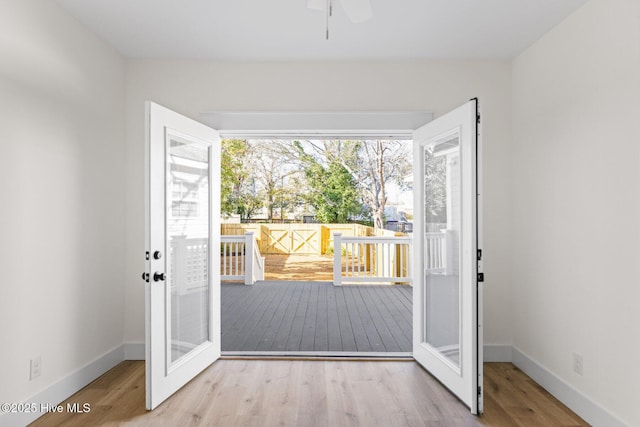 doorway with wood finished floors and baseboards