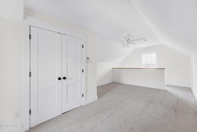 additional living space featuring a ceiling fan, lofted ceiling, carpet flooring, and baseboards