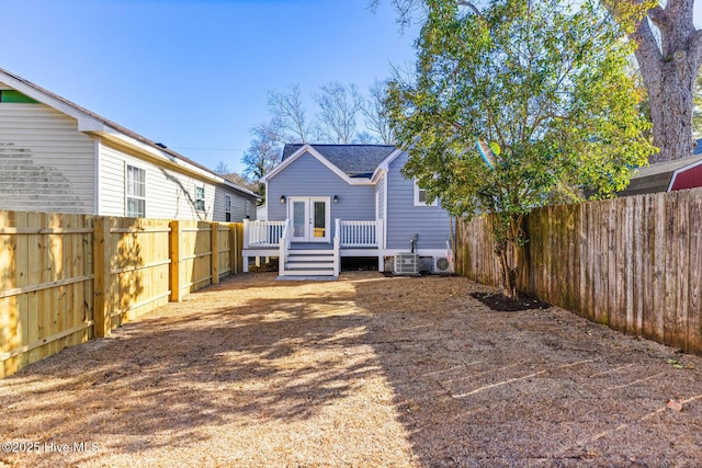 rear view of property featuring a deck, french doors, and a fenced backyard